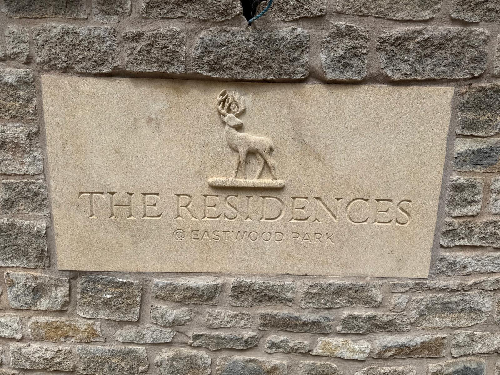 Entrance sign with The Residences logo carved in limestone 